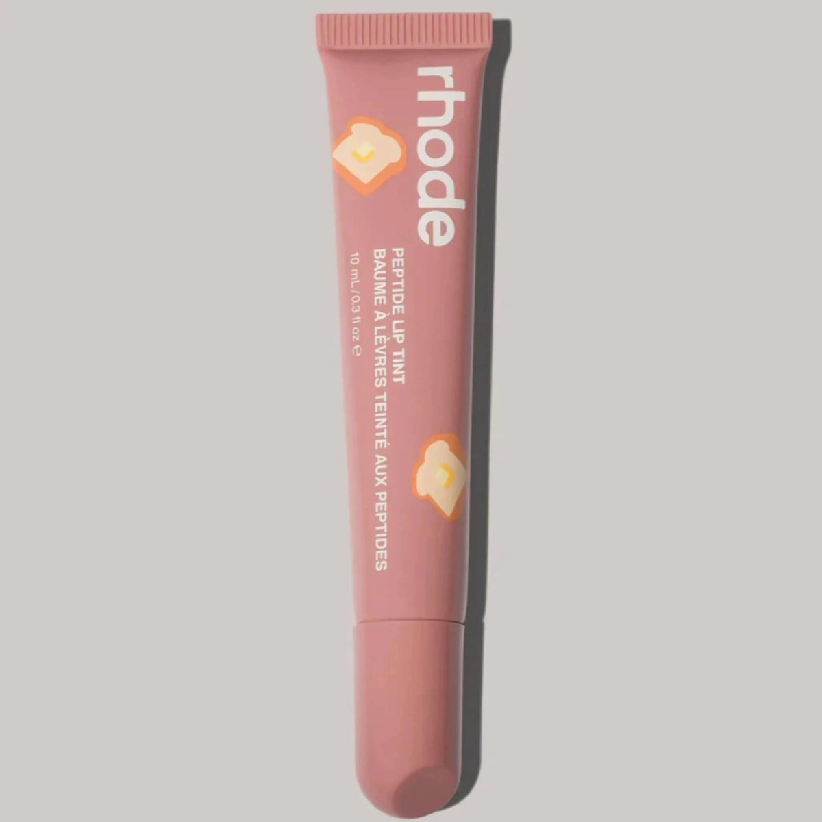 Pink lip balm tube with 'rhode' branding on a gray background